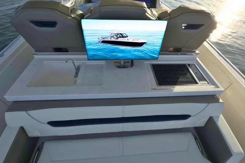 Slide: The Image of 2022 Tiara Yachts 34 LS interior with sink, grill, and TV screen on deck. - 19