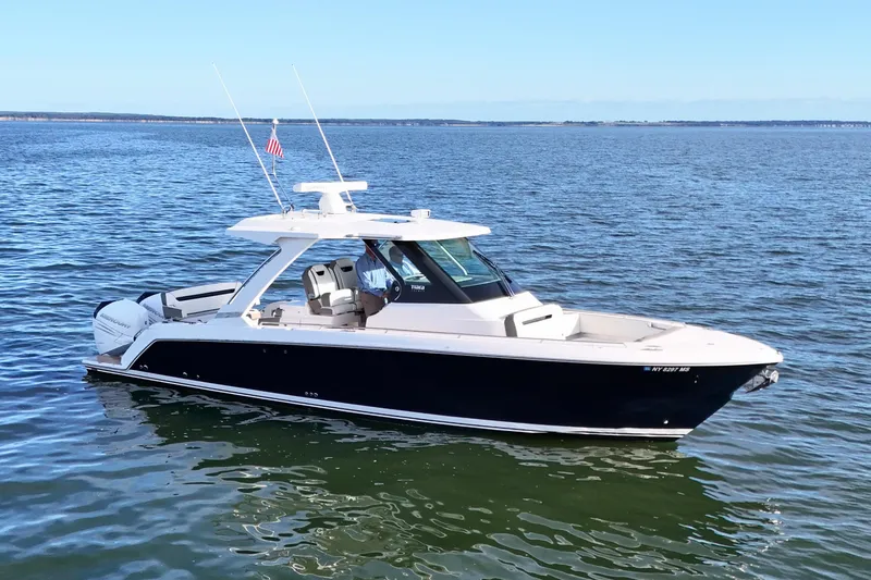 Slide: The Image of 2022 Tiara Yachts 34 LS boat on calm water, featuring sleek design and modern amenities. - 2