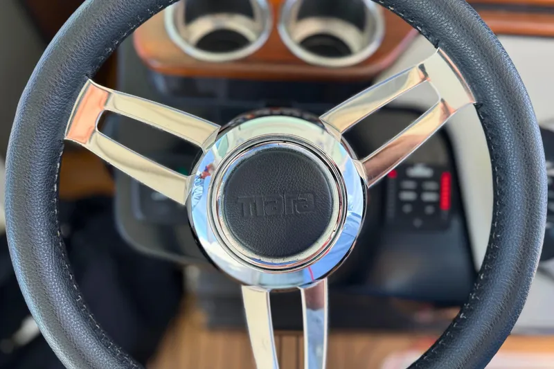 Slide: The Image of Steering wheel of 2022 Tiara Yachts 34 LS, featuring sleek chrome and leather design. - 29
