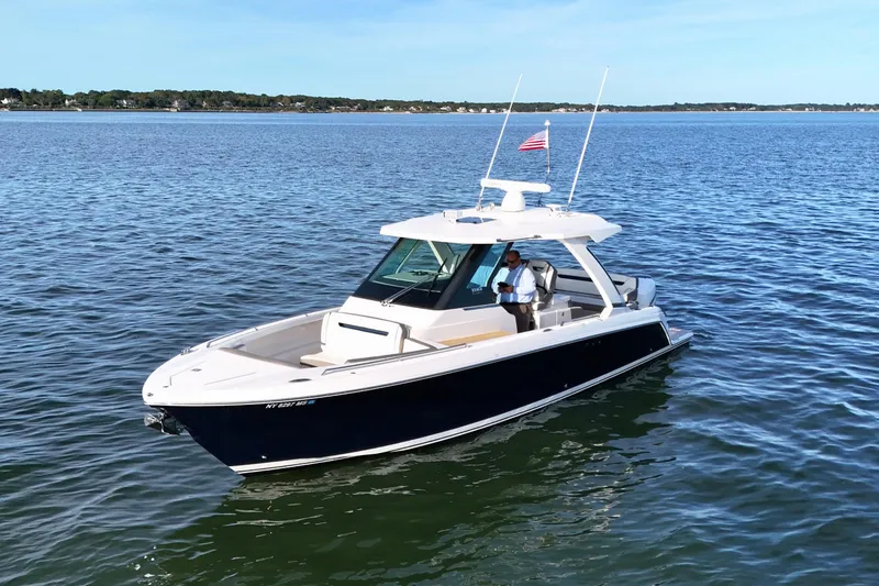 Slide: The Image of 2022 Tiara Yachts 34 LS boat on calm water with American flag. - 5