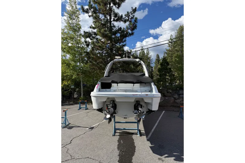 Slide: The Image of 2010 Formula 290 Sun Sport boat on stands, surrounded by trees and a clear sky. - 2