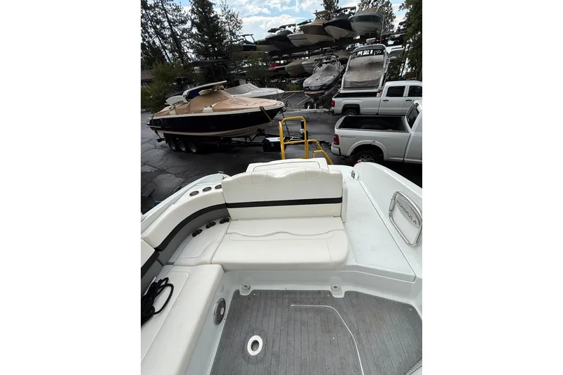 Slide: The Image of 2010 Formula 290 Sun Sport boat interior with seating, parked near other boats and vehicles. - 6