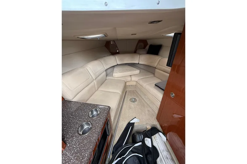 Slide: The Image of 2010 Formula 290 Sun Sport cabin with beige seating and compact kitchenette. - 8