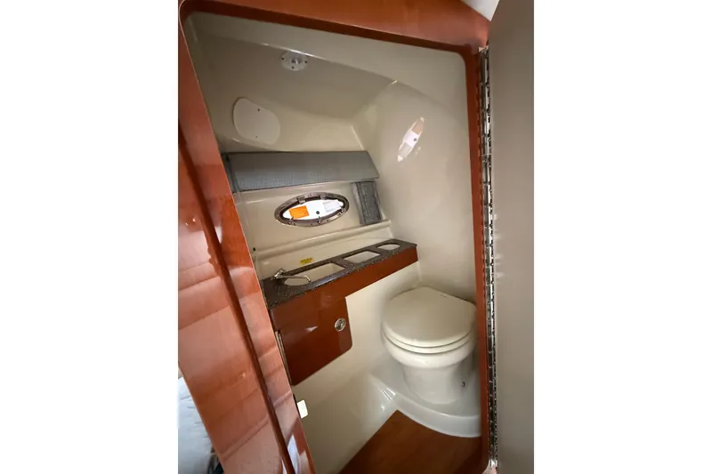 Slide: The Image of 2010 Formula 290 Sun Sport boat bathroom with wooden accents and porthole window. - 9