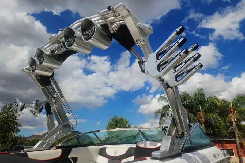 Slide: The Image of 2013 MasterCraft XStar boat with advanced wakeboard tower and speakers under a blue sky. - 3