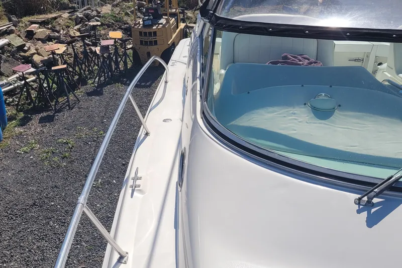 Slide: The Image of 1997 Sea Ray 330 Express Cruiser docked, showcasing sleek design and windshield details. - 10