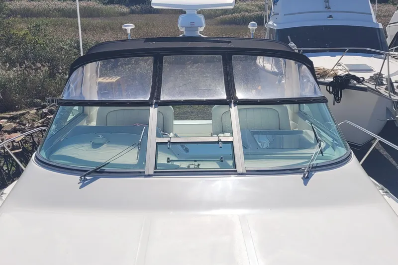 Slide: The Image of 1997 Sea Ray 330 Express Cruiser boat docked, front view with windshield and seating. - 13