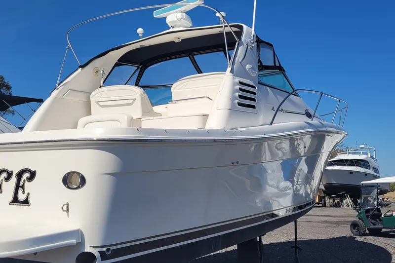 Slide: The Image of 1997 Sea Ray 330 Express Cruiser boat on display under clear blue sky. - 2