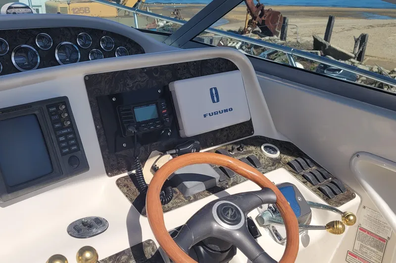 Slide: The Image of 1997 Sea Ray 330 Express Cruiser helm with Furuno navigation and wooden steering wheel. - 25