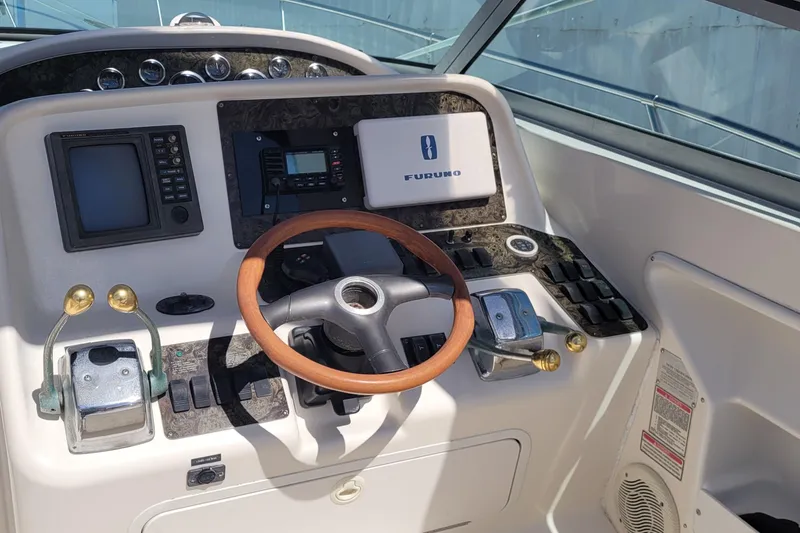 Slide: The Image of 1997 Sea Ray 330 Express Cruiser helm with wooden steering wheel and navigation equipment. - 26