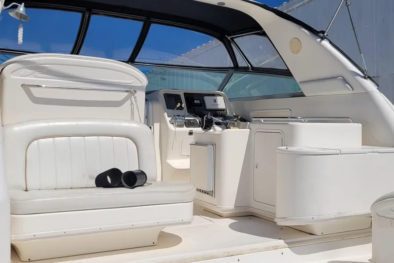 Slide: The Image of 1997 Sea Ray 330 Express Cruiser interior with white seating and control panel. - 28