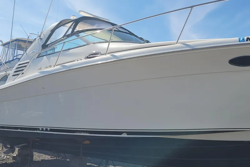 Slide: The Image of 1997 Sea Ray 330 Express Cruiser boat on display under clear blue sky. - 3