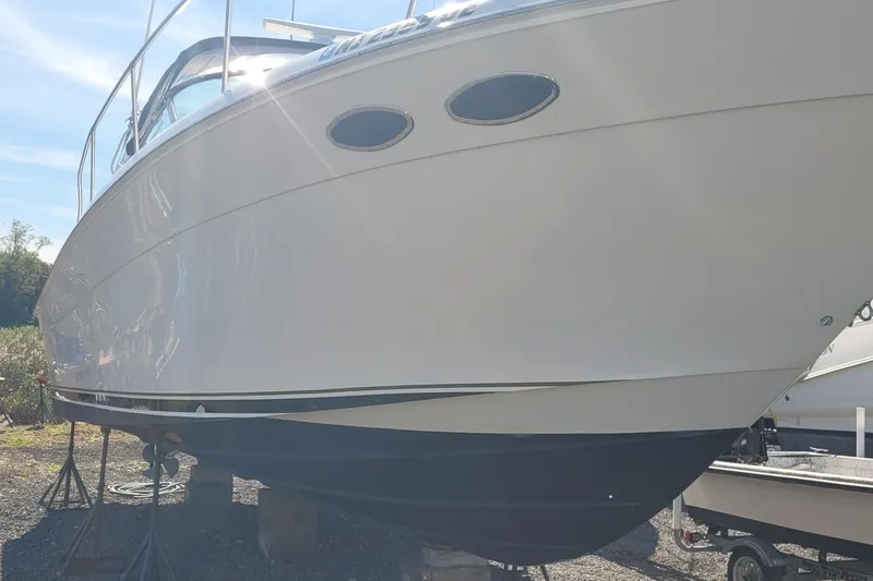 Slide: The Image of 1997 Sea Ray 330 Express Cruiser on stands, side view under sunlight. - 4