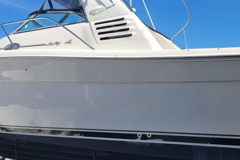 Slide: The Image of 1997 Sea Ray 330 Express Cruiser boat side view under clear blue sky. - 6