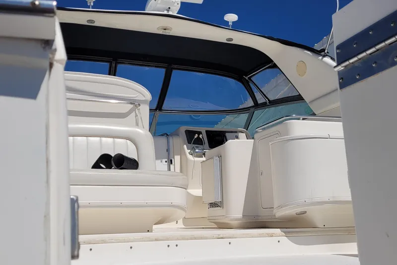 Slide: The Image of 1997 Sea Ray 330 Express Cruiser interior with white seating and control panel. - 9