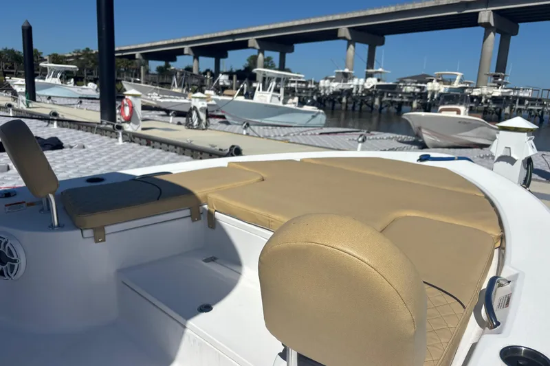 Slide: The Image of 2021 Sportsman Masters 247 Bay Boat at marina, featuring tan seating and spacious deck. - 10