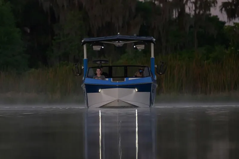 Slide: The Image of Manufacturer Provided Image: 2025 Nautique Super Air Nautique S23 on calm water at dusk, front view. - 20