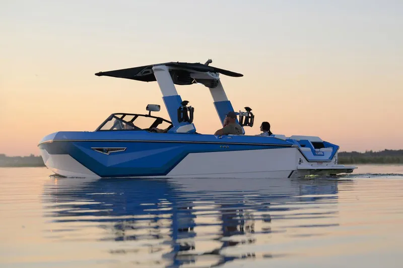 Slide: The Image of Manufacturer Provided Image: 2025 Nautique Super Air Nautique S23 boat on calm water at sunset. - 21