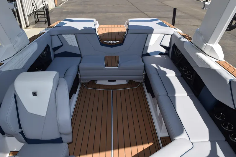 Slide: The Image of 2025 Nautique Super Air Nautique S23 interior with luxurious seating and teak flooring. - 6