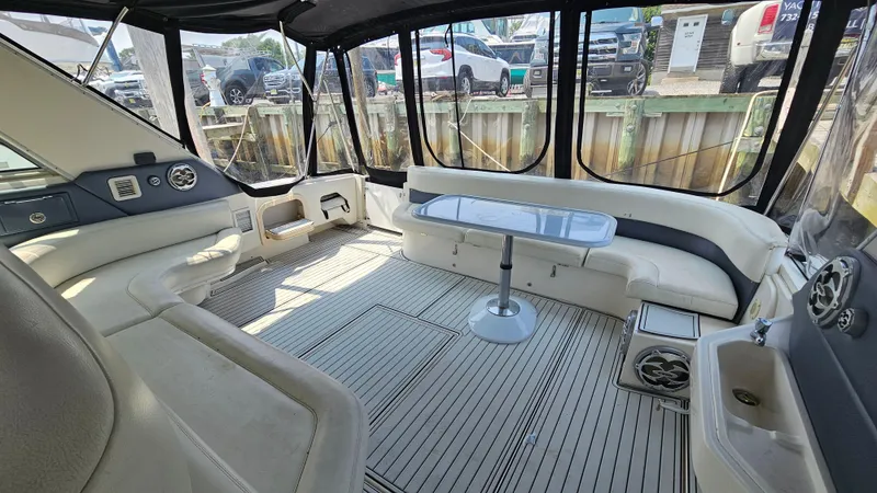 Slide: The Image of 1999 Sea Ray 500 Sundancer interior with spacious seating and table, featuring elegant design. - 13