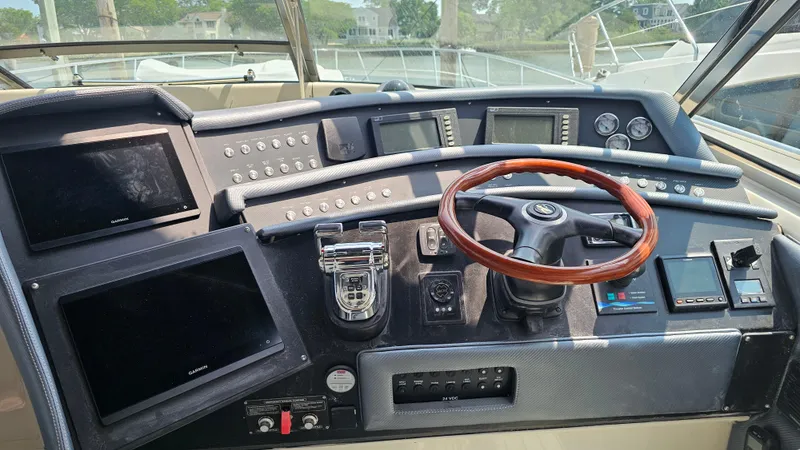 Slide: The Image of 1999 Sea Ray 500 Sundancer helm with wood steering wheel and modern navigation displays. - 15