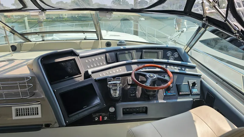 Slide: The Image of 1999 Sea Ray 500 Sundancer helm with modern navigation equipment and wooden steering wheel. - 16