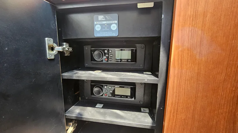 Slide: The Image of 1999 Sea Ray 500 Sundancer radio equipment in a wooden cabinet. - 24