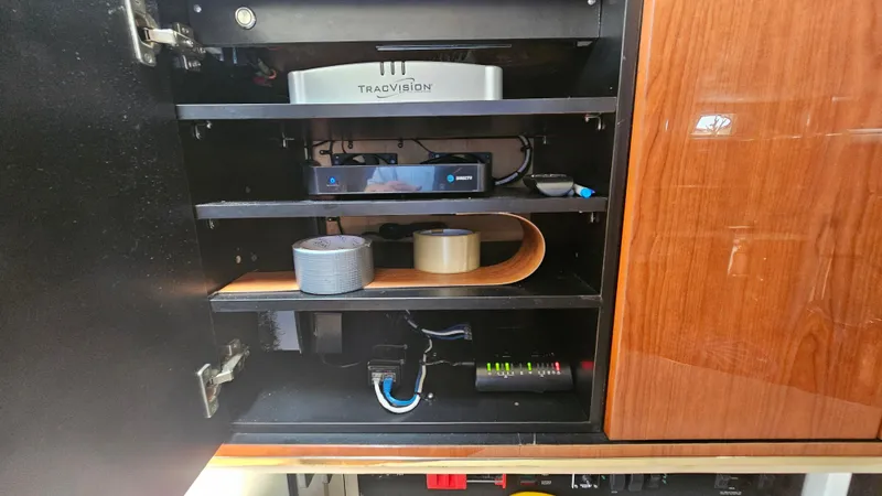 Slide: The Image of 1999 Sea Ray 500 Sundancer cabinet with electronic equipment and accessories neatly organized. - 25