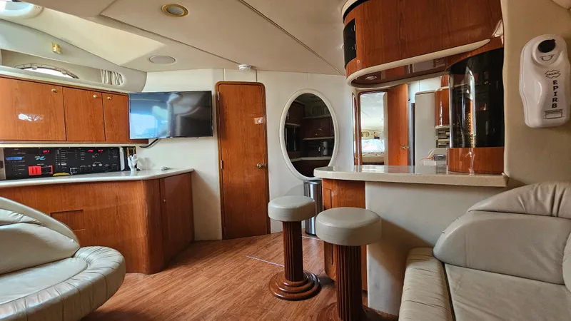 Slide: The Image of Interior of 1999 Sea Ray 500 Sundancer yacht with modern wood finishes and seating. - 26