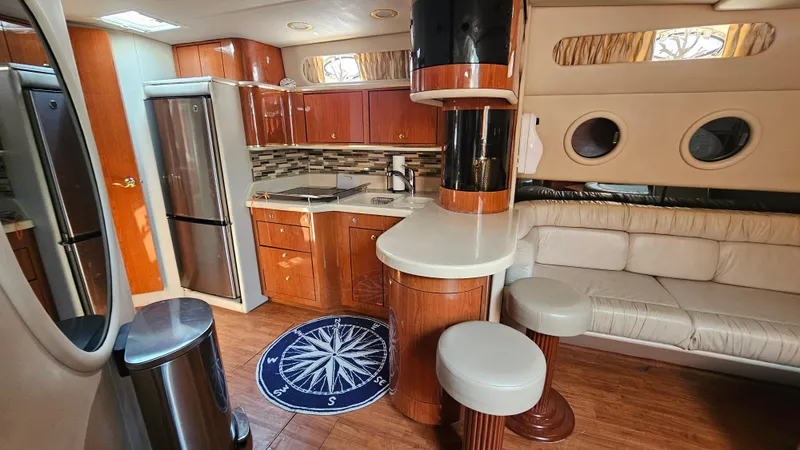 Slide: The Image of Luxurious interior of 1999 Sea Ray 500 Sundancer yacht with modern kitchen and seating area. - 28