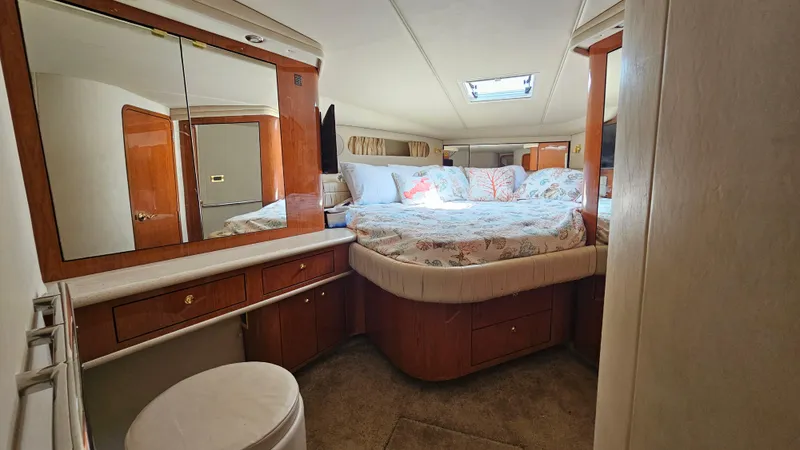 Slide: The Image of 1999 Sea Ray 500 Sundancer cabin interior with bed, mirror, and wooden cabinetry. - 29