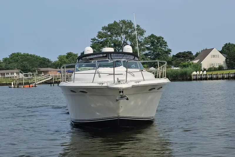 Slide: The Image of 1999 Sea Ray 500 Sundancer yacht on calm water near residential area. - 3