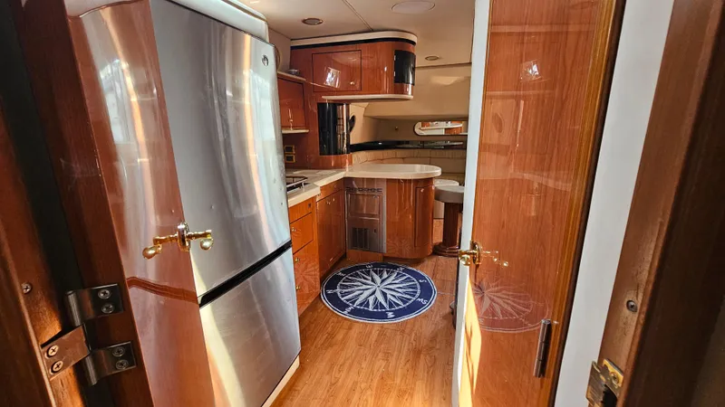 Slide: The Image of Interior of 1999 Sea Ray 500 Sundancer yacht with modern kitchen and wood finishes. - 32