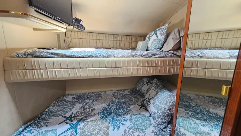 Slide: The Image of 1999 Sea Ray 500 Sundancer cabin with bunk beds and nautical-themed bedding. - 33
