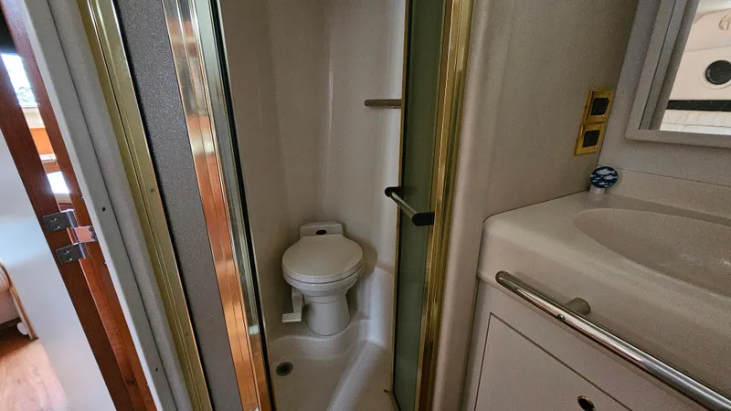 Slide: The Image of 1999 Sea Ray 500 Sundancer bathroom with toilet and sink. - 35