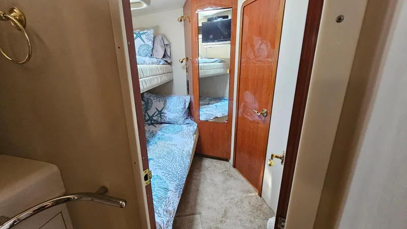 Slide: The Image of 1999 Sea Ray 500 Sundancer cabin with bunk beds and wooden doors. - 37