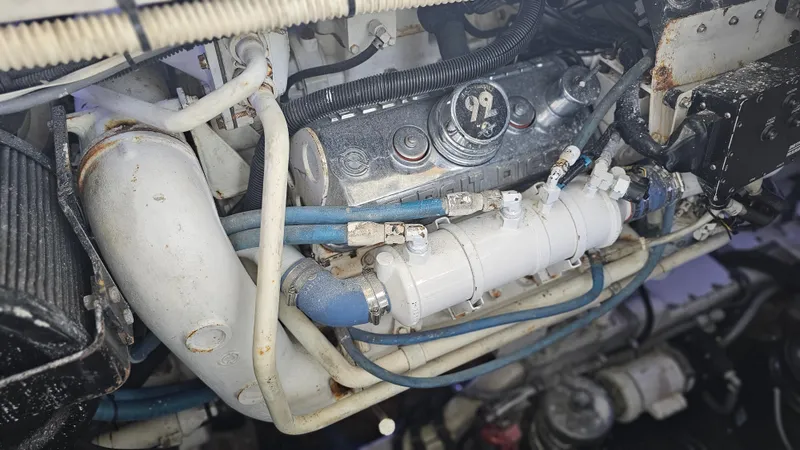 Slide: The Image of Engine components of a 1999 Sea Ray 500 Sundancer boat, featuring pipes and mechanical parts. - 42