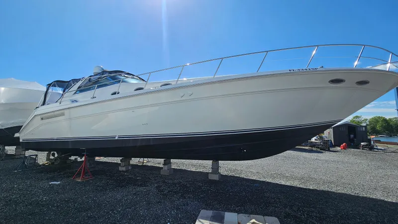 Slide: The Image of 1999 Sea Ray 500 Sundancer yacht on dry dock under clear blue sky. - 49