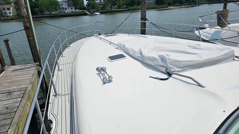 Slide: The Image of 1999 Sea Ray 500 Sundancer yacht docked by the water, showcasing its sleek deck design. - 6