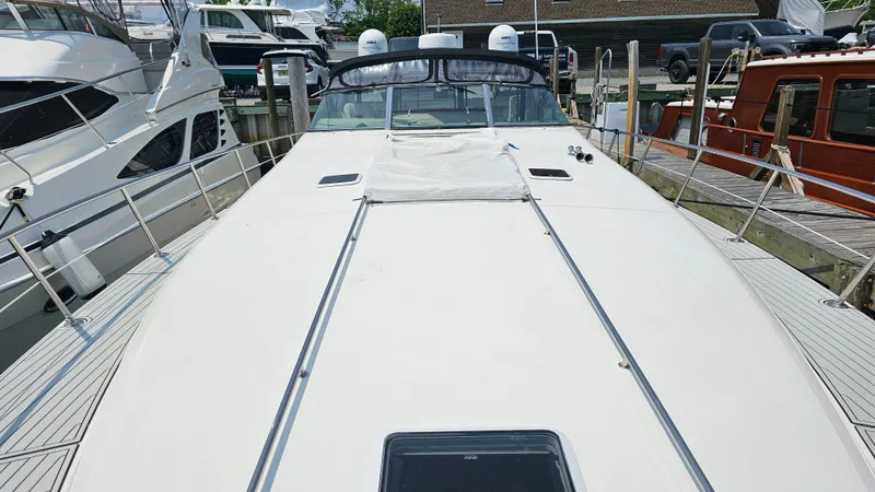 Slide: The Image of 1999 Sea Ray 500 Sundancer yacht docked, showcasing spacious deck and sleek design. - 7