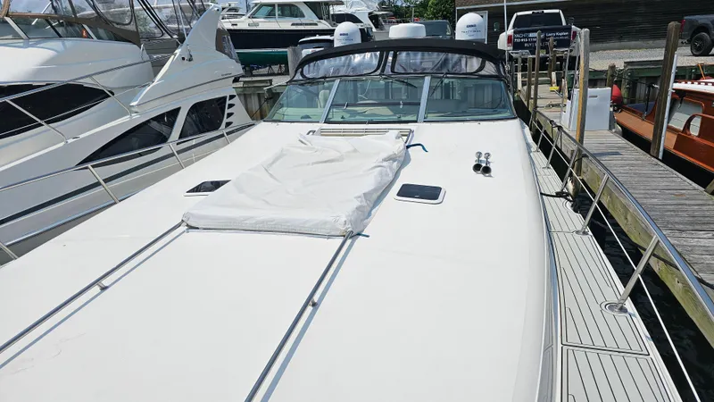 Slide: The Image of 1999 Sea Ray 500 Sundancer yacht docked at marina, showcasing sleek design and spacious deck. - 8