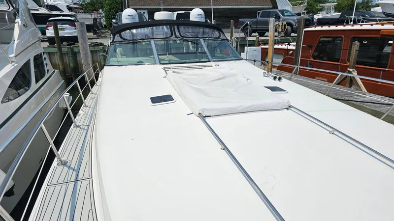 Slide: The Image of 1999 Sea Ray 500 Sundancer yacht docked at marina, showcasing sleek design and spacious deck. - 9