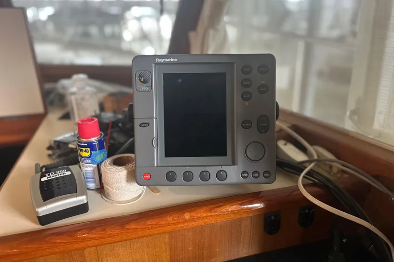 Slide: The Image of Raymarine navigation system on Island Gypsy 36, 2000 model, with tools and supplies nearby. - 8