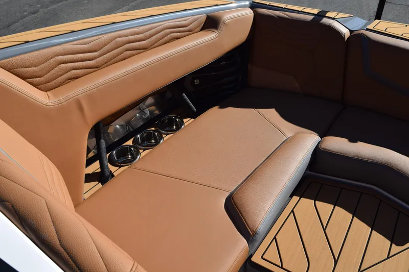 Slide: The Image of 2025 Nautique Super Air Nautique G23 Paragon interior with tan leather seating and cup holders. - 10