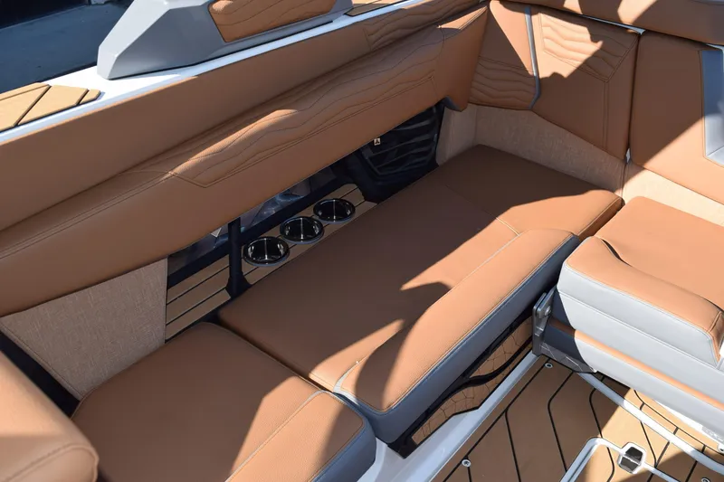 Slide: The Image of 2025 Nautique Super Air Nautique G23 Paragon interior with tan leather seating and cup holders. - 12