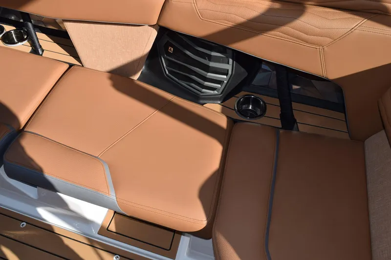Slide: The Image of 2025 Nautique Super Air Nautique G23 Paragon interior with tan leather seating and cup holder. - 14