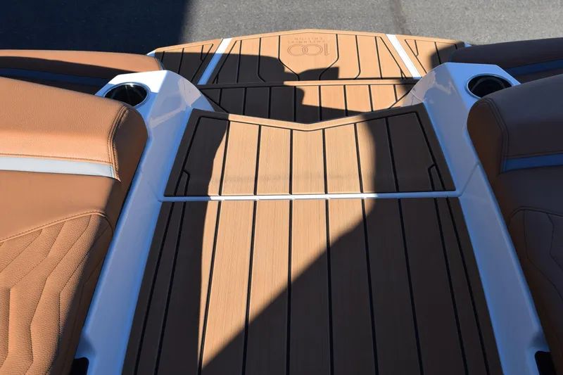 Slide: The Image of 2025 Nautique Super Air Nautique G23 Paragon deck with tan upholstery and cup holders. - 15