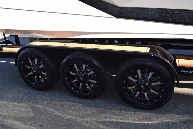Slide: The Image of 2025 Nautique Super Air Nautique G23 Paragon trailer with stylish black wheels. - 21