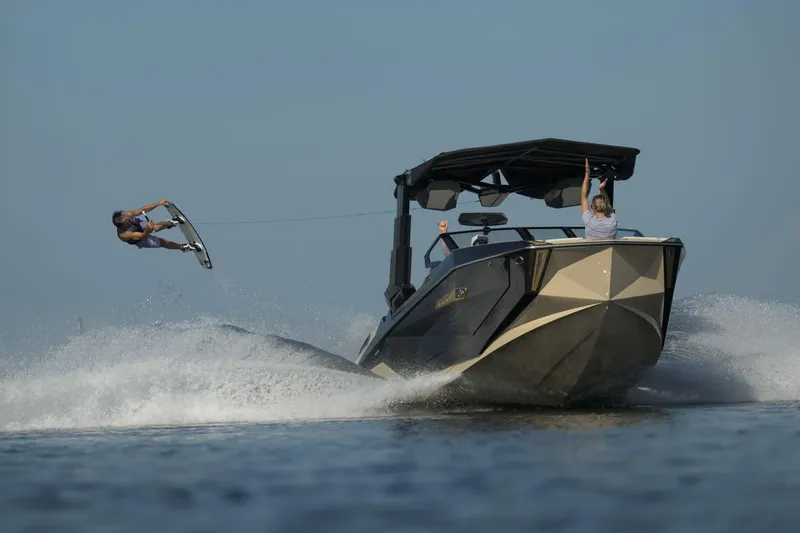 Slide: The Image of Manufacturer Provided Image: 2025 Nautique Super Air Nautique G23 Paragon towing a wakeboarder on a sunny day. - 25