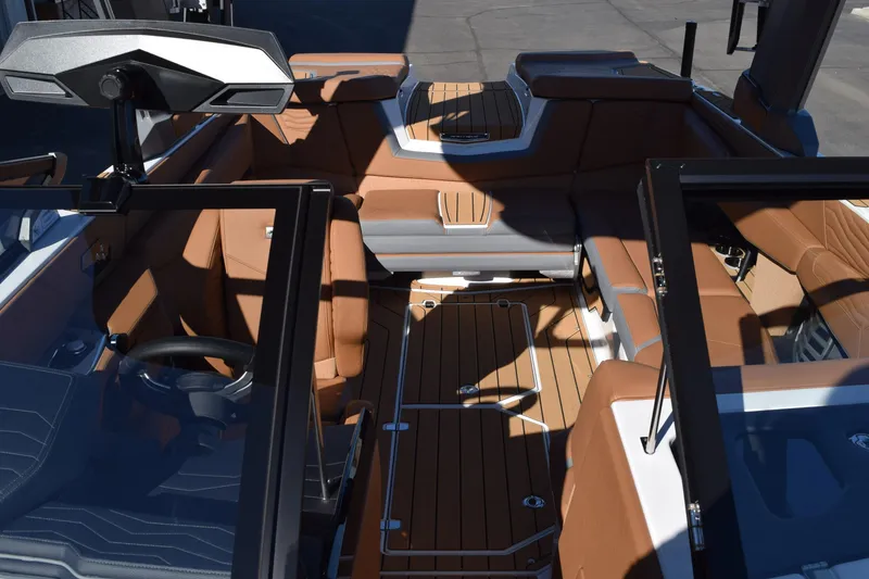 Slide: The Image of 2025 Nautique Super Air Nautique G23 Paragon interior with luxurious brown seating and sleek design. - 8